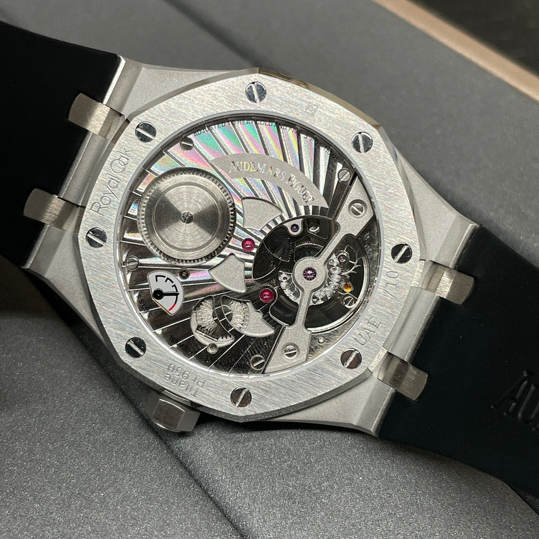 Audemars Piguet watch with exposed skeleton dial, metallic case, and black rubber strap