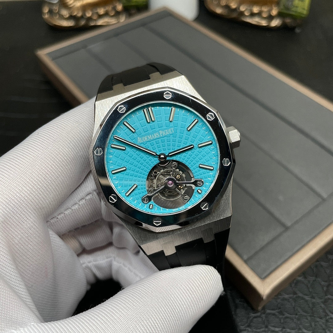 Audemars Piguet watch with blue dial, visible mechanical movement, and black rubber strap