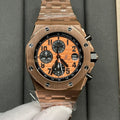 Rose-gold chronograph wristwatch with orange dial and black subdials, metal bracelet