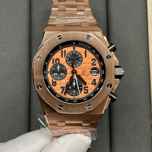 Rose-gold chronograph wristwatch with orange dial and black subdials, metal bracelet