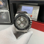 Audemars Piguet chronograph watch with dark dial, steel case, and gray strap