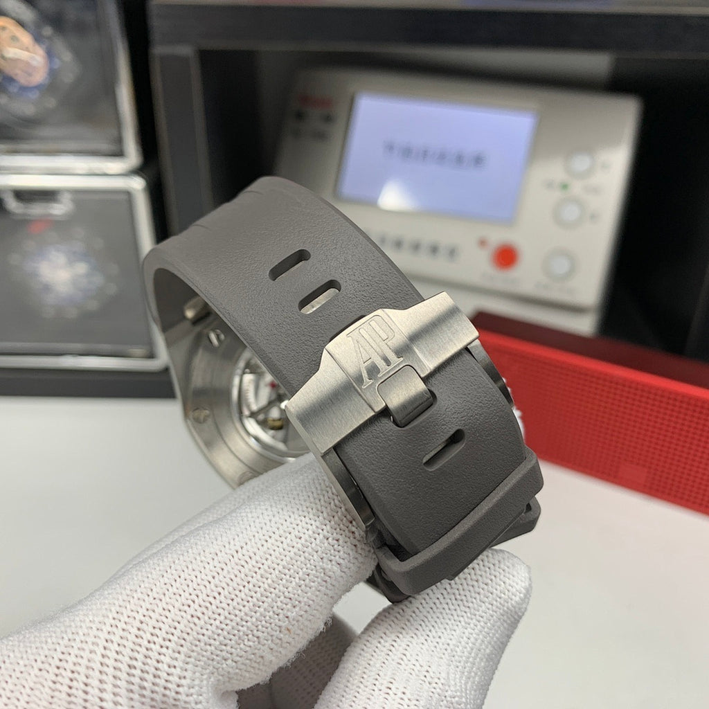 Watch crown-side view with gray rubber strap and brushed steel case
