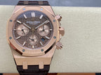 Rose gold chronograph watch with dark dial, subdials, and brown leather strap, front view