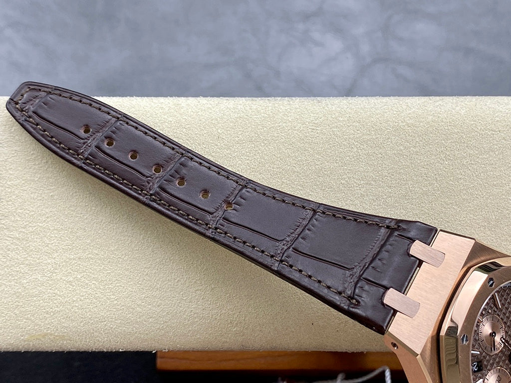 Brown leather watch strap with stitched edges and rose gold buckle, side view