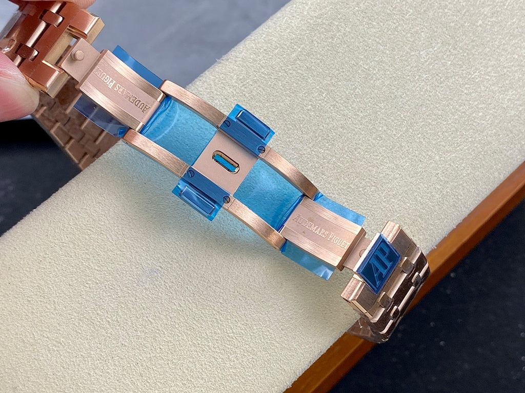 Rose-gold metal bracelet links with blue accents on a chronograph wristwatch