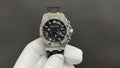 Stainless steel Audemars Piguet watch, black chronograph dial, diamond bezel, rubber strap.