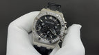 Stainless steel Audemars Piguet watch with black dial, diamond bezel, chronograph layout.