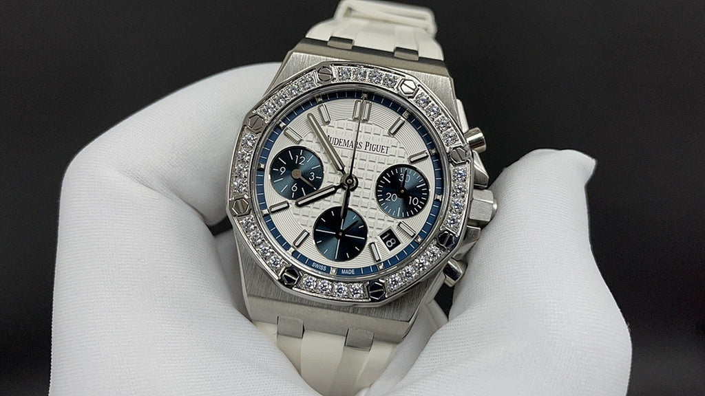Audemars Piguet watch with diamond bezel, blue subdials, and white rubber strap