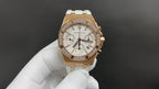 Audemars Piguet watch with white dial, gold bezel, and white rubber strap