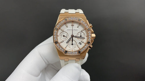 Audemars Piguet watch with white dial, gold bezel, and white rubber strap