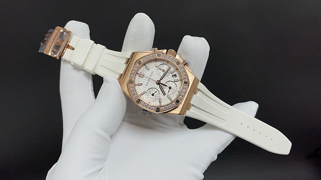 Audemars Piguet watch with white dial and gold case, diamond bezel, white rubber strap