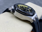 Luxury sports watch with dark dial and dark rubber strap shown at a three-quarter angle