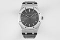 Audemars Piguet watch with dark dial, silver bezel, and black rubber strap