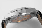Stainless steel wristwatch case side view with open back and inner components visible