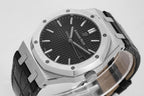 Stainless steel wristwatch close-up with black textured dial and black leather strap