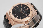 Audemars Piguet watch close-up: rose gold case, black textured dial, and black leather strap.