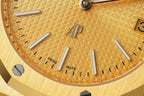 Gold-tone dial close-up with baton hour markers and text 'SWISS' and 'MADE'