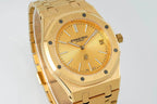 Gold-tone watch front with champagne dial, baton markers, and date at 3