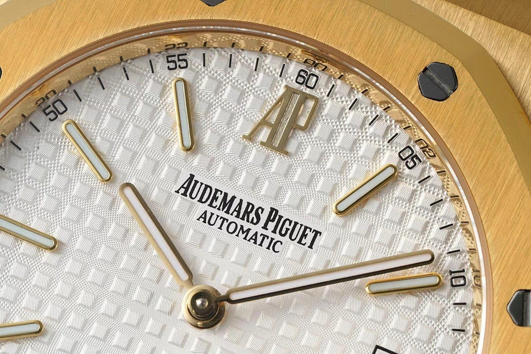 Close-up of gold-tone wristwatch dial with logo, Automatic text, and gold hands