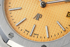 Champagne dial close-up with baton markers, Swiss and Made text, silver hands