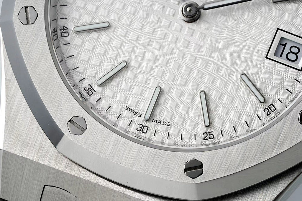 Audemars Piguet watch face close-up with baton markers and date window at 18