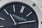 Blue dial watch face with baton hour markers and three prominent hands