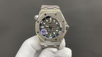 Audemars Piguet stainless steel watch on white glove, black dial with blue accent detail