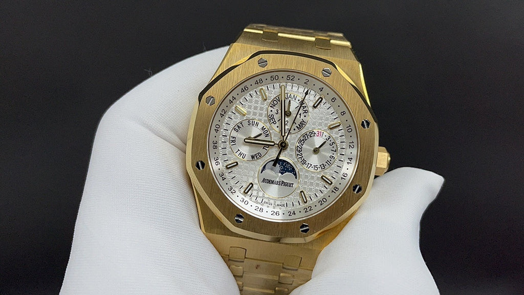 Gold-tone luxury wristwatch with white dial, chronograph subdials, and bracelet