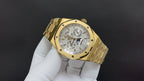 Gold-tone luxury wristwatch with white dial and metal bracelet, angled view