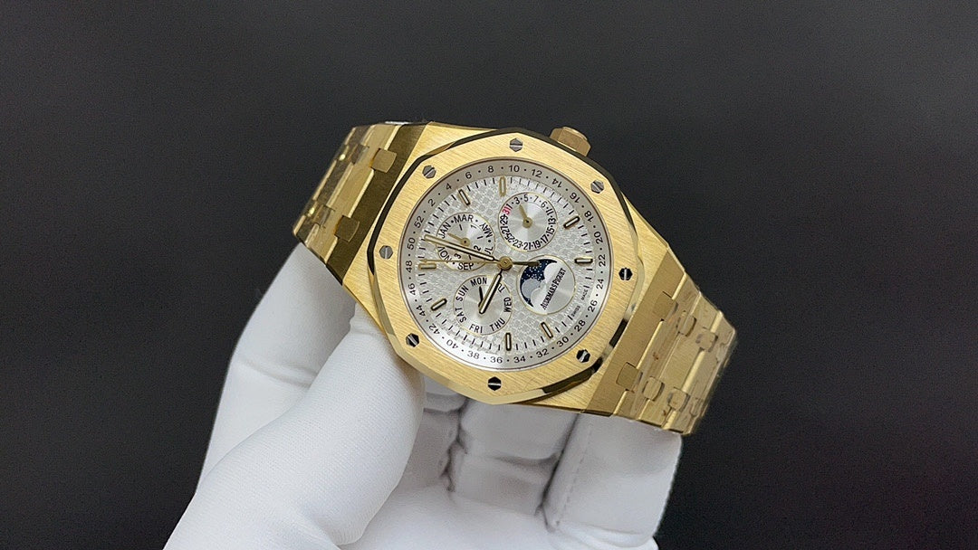 Gold-tone luxury wristwatch with white dial and metal bracelet, angled view
