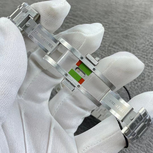 Audemars Piguet watch clasp with silver metal bracelet links and multi-color emblem
