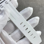 White rubber watch strap with rectangular links and adjustment holes.