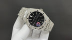 Audemars Piguet watch with black dial and textured center, metal bracelet on white gloves