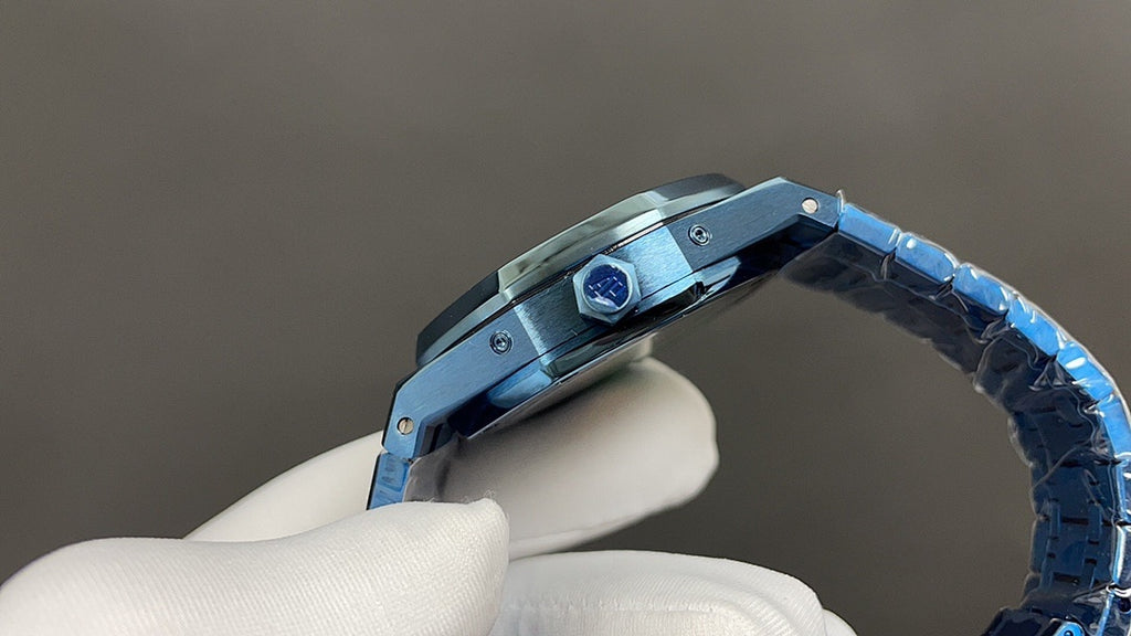 Audemars Piguet watch crown and bezel detail with blue bracelet links in white glove