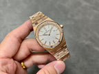 Gold-tone wristwatch with diamond bezel, textured silver dial, and date window