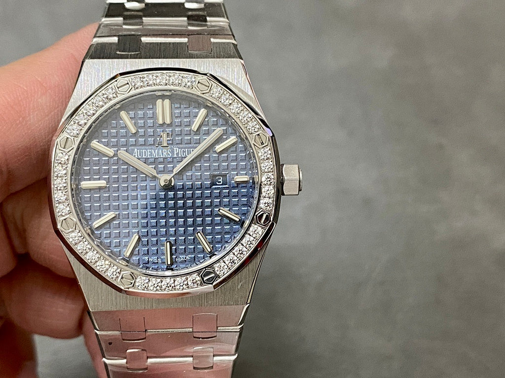Luxury steel watch with blue textured dial, gold baton hands, diamond bezel