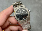 Audemars Piguet watch front close-up with black textured dial, steel bezel and bracelet links