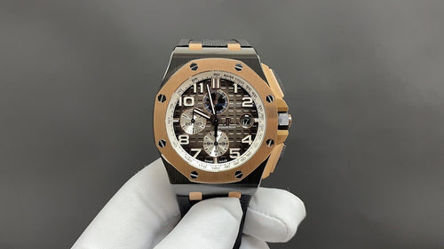 Audemars Piguet Royal Oak watch with gold-toned case, black dial, black rubber strap