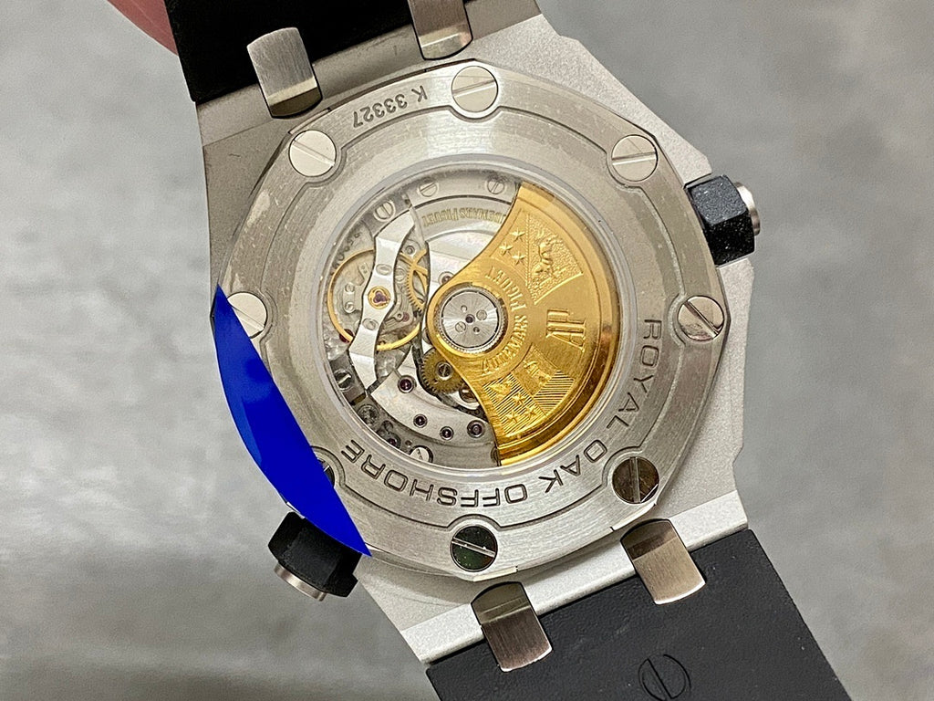 Stainless steel watch case back showing exposed golden mechanical movement