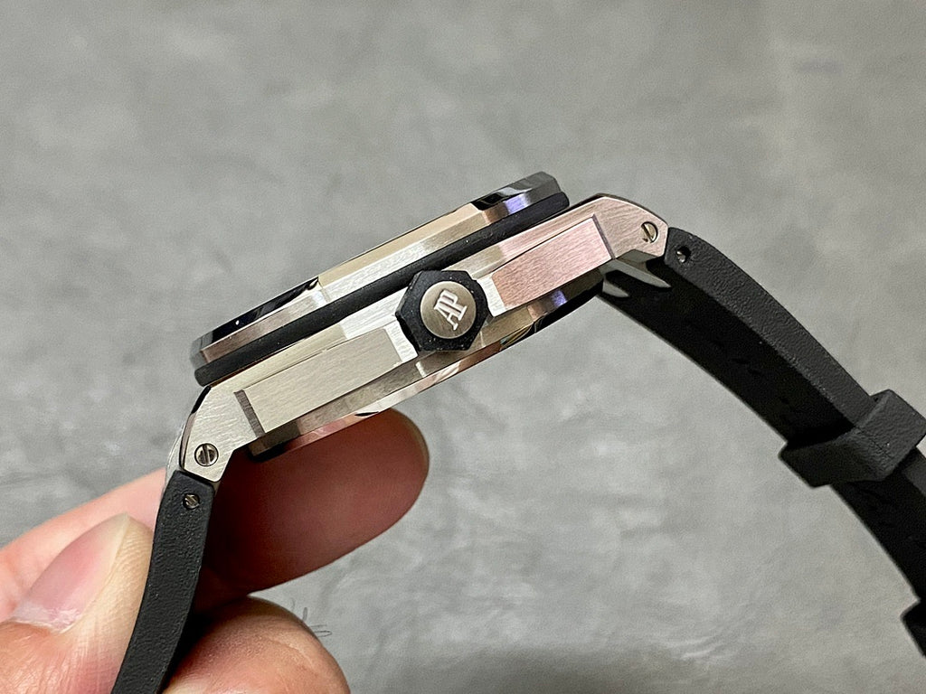 Stainless steel watch case with black rubber strap and AP logo on the bezel