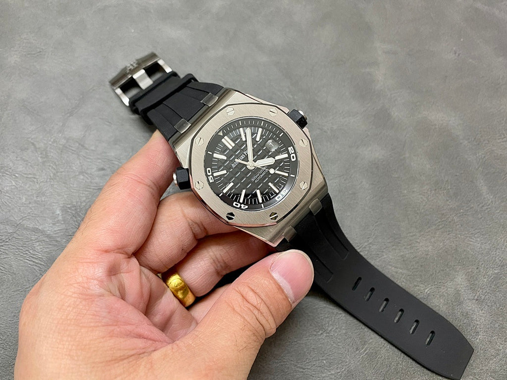 Luxury sports watch on black rubber strap with black dial and gold-toned detail