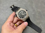 Luxury sports watch on black rubber strap with black dial and gold-toned detail