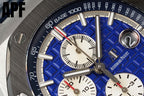 Blue dial wristwatch close-up with white subdials and metal hour markers