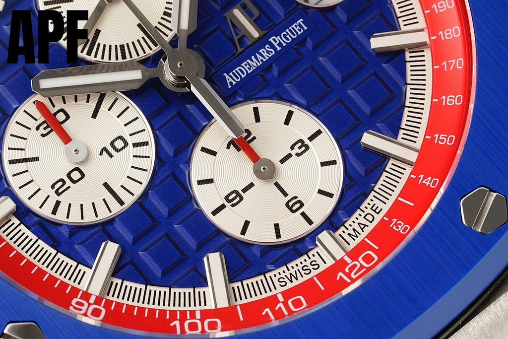 Chronograph watch dial close-up with blue textured face, white subdials, red bezel