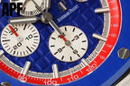 Chronograph watch dial close-up with blue textured face, white subdials, red bezel