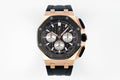 Audemars Piguet watch with black dial, rose-gold octagonal case, black rubber strap.