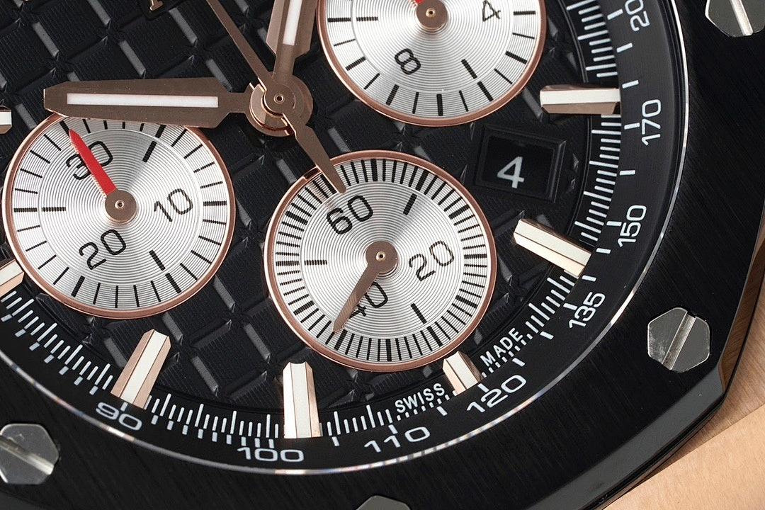 Audemars Piguet watch dial close-up, black face with white subdials and red accents.