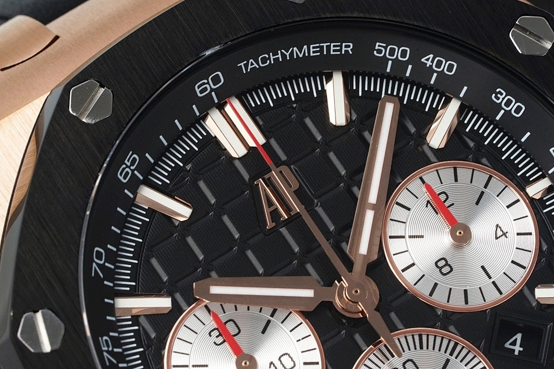 Audemars Piguet watch tachymeter ring close-up, black dial with rose-gold hands.