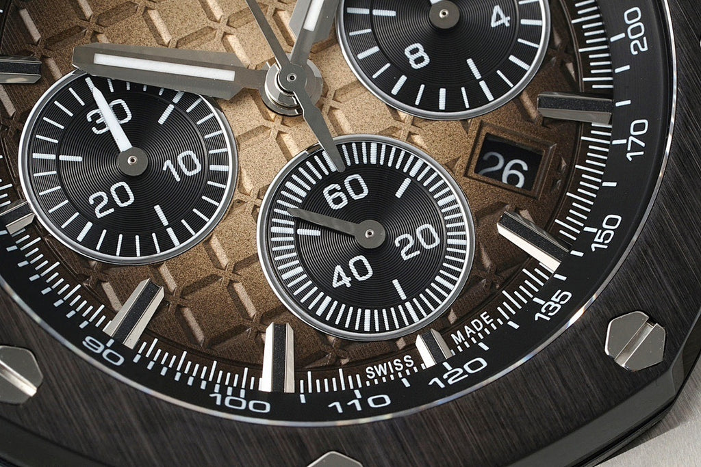 Sports watch dial close-up with black tachymeter markings and subdials