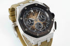 Sports watch with black dial and tan rubber strap, angled view